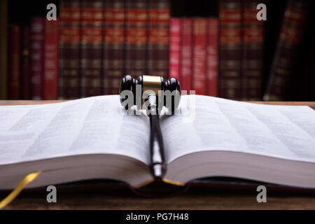 Nahaufnahme eines offenen Gesetz Buch und Holzhammer im Gerichtssaal Stockfoto