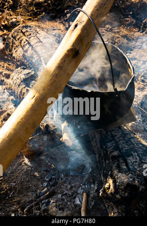 Kochen im Kessel über offenem Feuer. Blick von oben. Gesunde Nahrung auf natürliche Weise hergestellt Stockfoto