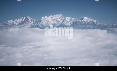 Der Himalaya als von einem Flugzeug in Nepal gesehen. Schicht von Wolken unter dem Berggipfel. Stockfoto