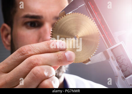 Close-up von der Größe eines Menschen Hand Messgetriebe mit digitalen elektronischen Messschieber Stockfoto