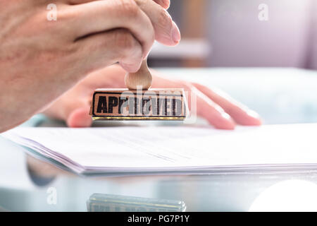 In der Nähe von einem Geschäftsmann Hand Stanzen Genehmigt auf Dokument Stockfoto