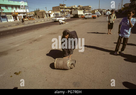 Bagdad, Irak - Oktober 1995 - Eine ältere irakische Frau rollt eine Butan Zylinder in der Straße Markt im Zentrum von Bagdad. Von Irakischen aufgrund der strengen UN-Sanktionen in den 90er kämpfen auferlegt, weil der irakischen Invasion in Kuwait im Jahr 1990. Stockfoto