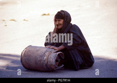 Bagdad, Irak - Oktober 1995 - Eine ältere irakische Frau rollt eine Butan Zylinder in der Straße Markt im Zentrum von Bagdad. Von Irakischen aufgrund der strengen UN-Sanktionen in den 90er kämpfen auferlegt, weil der irakischen Invasion in Kuwait im Jahr 1990. Stockfoto