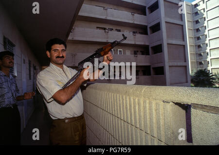 Freudige irakischen Feuern Waffe aus seinem Apartment Block Balkon, in der Feier von Präsident Saddam Hussein überwältigenden Sieg im einzigen Kandidaten Wahlen mit einer einzigen Frage "Möchten Sie von Saddam Hussein als Präsident der Republik genehmigt werden?" "Ja" oder "Nein", Referendum, von denen er 99,6% gewonnen. Stockfoto