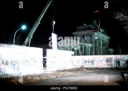 Berliner Mauer 1989 - Ostdeutsche wachen Fotografieren als Kran einen Abschnitt der Berliner Mauer neben dem Brandenburger Tor entfernt. Stockfoto