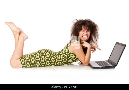 Schöne Funny Girl mit dem Laptop liegt, und gibt ein Zunge auf einer Etage auf weißem Hintergrund Stockfoto