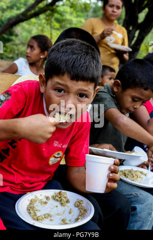 Managua, Nicaragua - Mai 11, 2017: Kinder essen eine Mahlzeit von angereicherter Reis durch amerikanische Missionare an ihre Kirche in Nicaragua zur Verfügung. Stockfoto