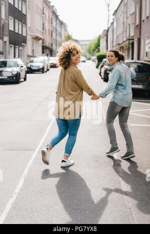 Beste Freunde Spaß in der Stadt, halten sich an den Händen Stockfoto