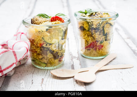 Couscous mit gegrilltem Gemüse, Aubergine, Zucchini, Paprika, Tomaten, roten Zwiebeln, Rosmarin und Basilikum Stockfoto