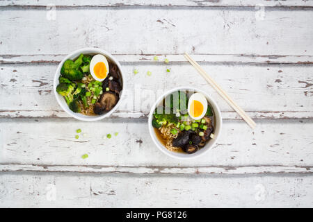 Zwei Schalen mit Ramen Suppe mit Ei, Brokkoli, Nudeln, Shitake Pilzen und Frühlingszwiebeln Stockfoto