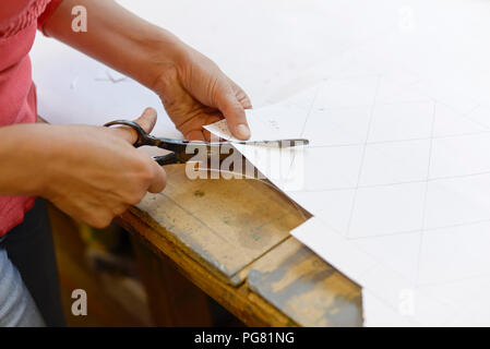 In der Nähe von Frau Schneiden von Papier vom Entwurf in Glaser's Werkstatt Stockfoto