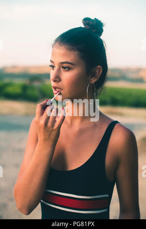 Portrait von Teenager in der Natur der Anwendung Lip Gloss Stockfoto