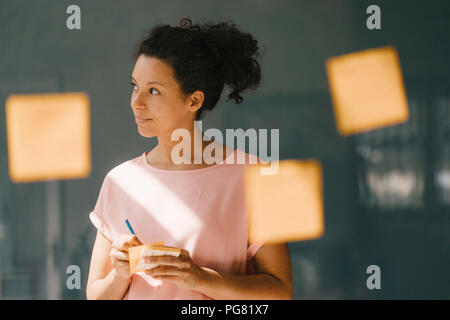 Frau Brainstorming in Office usine Haftnotizen Stockfoto