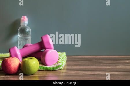 Gesunden und aktiven Lebensstil Hintergrund Konzept. Grüne und rote Äpfel, Hanteln und eine Flasche Wasser auf Holz Stock mit kopieren. Stockfoto