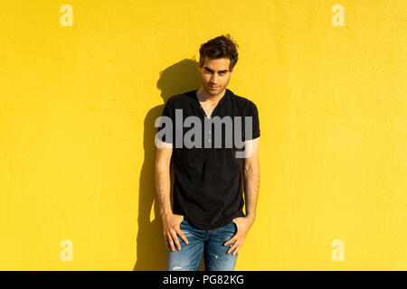 Mann, der vor der gelben wand, Porträt Stockfoto