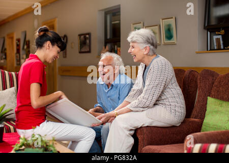 Krankenschwester lehre Senioren im Altenheim, wie Laptop zu verwenden Stockfoto