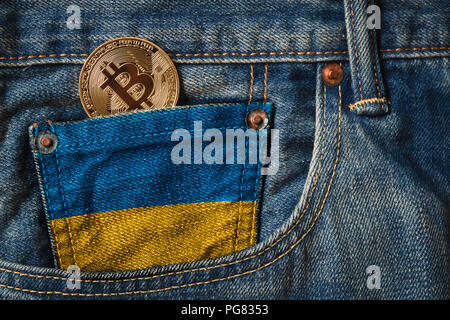 Golden BITCOIN (BTC) cryptocurrency in der Tasche der Jeans mit der Flagge von Ukraine Stockfoto