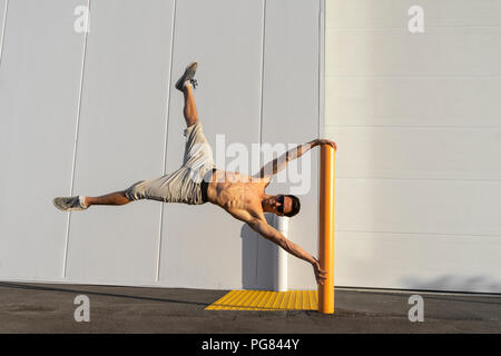 Acrobat Schulung auf einem Pfosten Stockfoto