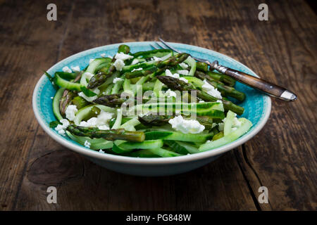 Schüssel grünem Spargel Salat mit spiralförmig aufgewickelt, Gurken und Fetakäse Stockfoto