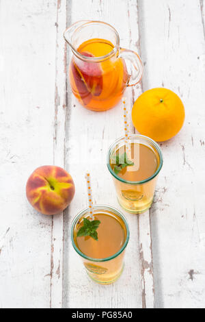 Gläser und Glas Pfirsich Orange Eistee auf Holz Stockfoto