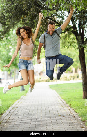 Sorglos Paar in Park springen Stockfoto