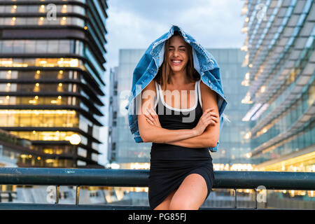 Porträt der glückliche junge Frau mit schwarzen Kleid in die Stadt in der Dämmerung Stockfoto