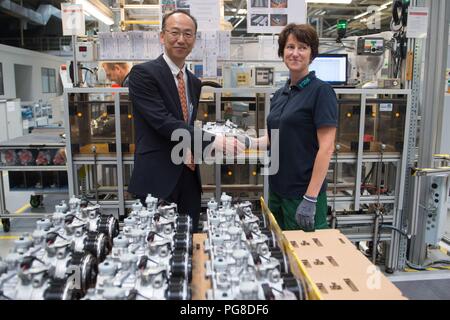 Bernsdorf, Deutschland. 24 Aug, 2018. Mitarbeiter Elke Urbetat Hände über den 50-millionsten Kompressor an der Produktionslinie zu Sokichi Hibino, Geschäftsführer der TD Deutsche Klimakompressor GmbH (TDDK). Am Freitag, den 50-millionsten Kompressor wurde an der Produktionslinie übergeben. TDDK ist ein Unternehmen der beiden japanischen Automobilhersteller Toyota Industries Corporation und Denso Corporation. Credit: Sebastian Kahnert/dpa-Zentralbild/dpa/Alamy leben Nachrichten Stockfoto