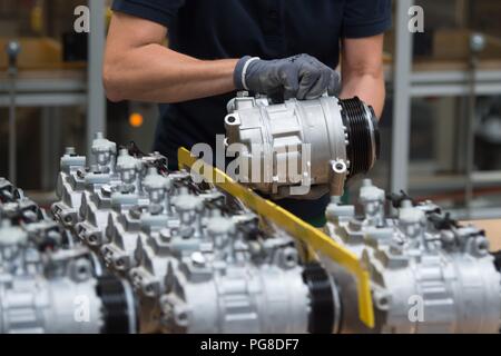 Bernsdorf, Deutschland. 24 Aug, 2018. Ein Mitarbeiter von TD Deutsche Klimakompressor GmbH (TDDK) Sortiert die Kompressoren. Am selben Tag wurde die 50-millionste Kompressor wurde an der Produktionslinie übergeben. TDDK ist ein Unternehmen der beiden japanischen Automobilhersteller Toyota Industries Corporation und Denso Corporation. Credit: Sebastian Kahnert/dpa-Zentralbild/dpa/Alamy leben Nachrichten Stockfoto