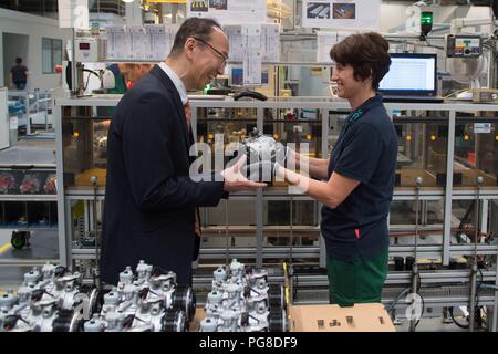 Bernsdorf, Deutschland. 24 Aug, 2018. Mitarbeiter Elke Urbetat Hände über den 50-millionsten Kompressor an der Produktionslinie zu Sokichi Hibino, Geschäftsführer der TD Deutsche Klimakompressor GmbH (TDDK). Am Freitag, den 50-millionsten Kompressor wurde an der Produktionslinie übergeben. TDDK ist ein Unternehmen der beiden japanischen Automobilhersteller Toyota Industries Corporation und Denso Corporation. Credit: Sebastian Kahnert/dpa-Zentralbild/dpa/Alamy leben Nachrichten Stockfoto