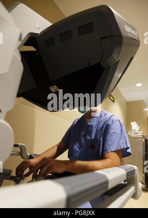 August 24, 2018 - Davenport, Iowa, USA - Andrew J. Lightfoot, MD von urologischen Teilnehmern sitzt an der Konsole des Da Vinci chirurgischen Systems und steuert die Roboterarme, während in einer stereoskopischen überwachen, die eine vergrößerte, High Definition 3D-Ansicht der chirurgischen Bereich. (Bild: © Kevin E. Schmidt/Viererkabel - Zeiten/Viererkabel - Zeiten über ZUMA Draht) Stockfoto
