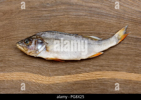 Salzig trockenen Fluss Fisch Barsch, Bass auf eine beeindruckende hölzerne Hintergrund. Stockfoto