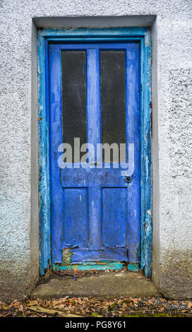 Alten verrotteten vorne Holztür mit blauer Farbe blätterte. Stockfoto