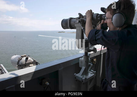 180819-N-QQ 548-0043 ATLANTIK (Aug. 19, 2018) Operations Specialist 2. Klasse Ian Boisvert steht zusehen, wie der nimitz-Klasse Flugzeugträger USS Abraham Lincoln (CVN 72) fährt Naval Station Norfolk. (U.S. Marine Foto von Mass Communication Specialist 3. Klasse Tyler C. Priestley/Freigegeben) Stockfoto