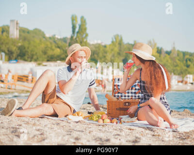 Junges Paar Ausgabe Zeit auf Datum zusammen am Strand. Freund und Freundin auf Picknick. Sie entspannen, trinken, lieben sich. Verhältnis c Stockfoto