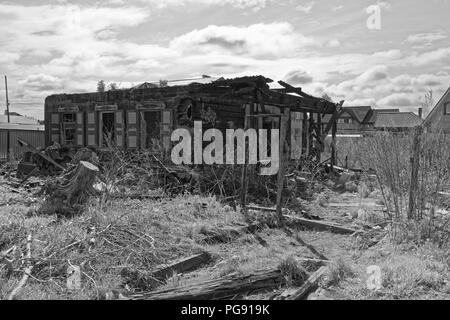 Alte verbrannte Haus gegen bewölkter Himmel als schwarz-weiß-Bild. Komsomolsk-on-Amure, Russland Stockfoto