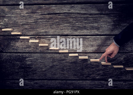 Retro Vintage Style Bild von einem Geschäftsmann seine Finger bis zu Holz- Schritte in Richtung Licht, ähnlich einer Treppe im rustikalen hölzernen Brettern. Stockfoto