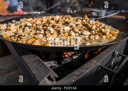 Frische Muscheln im Grill Pfanne. Seafood Grill im Freien. Picknick gesundes Essen, Muscheln ohne Schale. Fisch, Gegrilltem appetitlich Muscheln auf einer schwarzen Platte Stockfoto