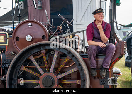 Mann sitzt auf einer Zugkraft bei Steam Fair in England Stockfoto