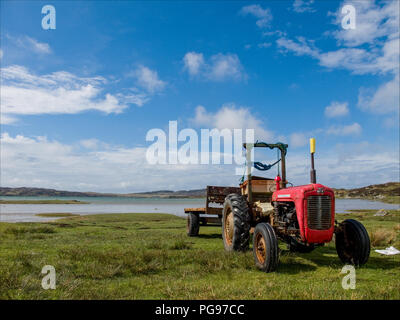Ein Roter Traktor auf der Faser eine Flutwelle Causeway zwischen den Inseln Colonsay und Oransay in der Inneren Hebriden Schottland geparkt Stockfoto