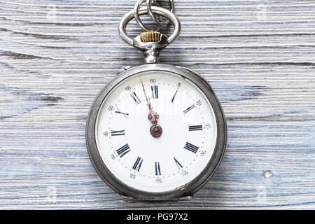 Zwei Minuten vor zwölf Uhr auf antike Taschenuhr auf grau Holz- Hintergrund Stockfoto