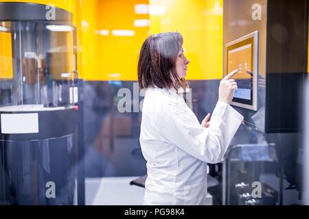 Techniker die Programmierung einer Maschine in einer Nano-faser Labor. In dieser Übung wird über nanofasern biologisch abbaubare Werkstoffe für Gewebe Gerüste zu fertigen. Stockfoto