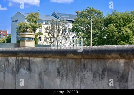 Berlin, Deutschland. Sommer. August 2018. Berliner Mauer Überbleibsel und Wachturm mit Suchscheinwerfer durch die ackerstraße. Stockfoto