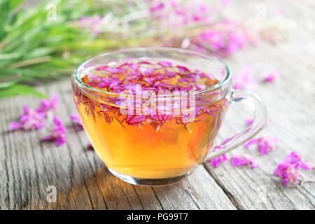 Fireweed gesunden Kräutertee. Tasse Kaffee- und chamerion Bündel Heilkräuter auf Hintergrund, nicht im Fokus. Stockfoto