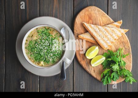 Suppe mit Meeresfrüchten mit Toast auf hölzernen Hintergrund Stockfoto