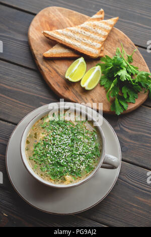 Suppe mit Meeresfrüchten mit Toast auf hölzernen Hintergrund Stockfoto