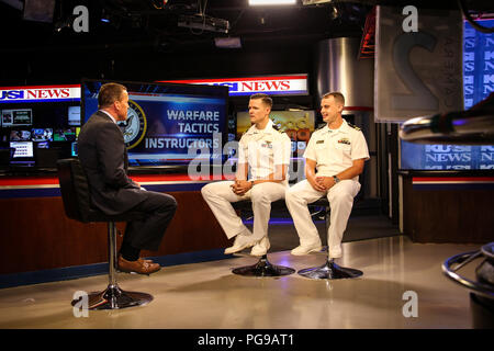 SAN DIEGO (Aug. 18, 2018) Leutnant Matt Clark, Mitte, und Leutnant Kaleb Bekemeier, rechts, Kriegsführung Taktiken Ausbilder (WTI) von Naval Oberfläche und Mine Warfighting Development Center (SMWDC) sitzen in einem Interview mit dem Sender Jason Austell auf KUSI's Good Morning San Diego. Clark und Bekemeier diskutiert das WTI-Programm, dessen Auswirkung auf die Flotte Letalität und taktischen Kenntnisse, und WTI die Teilnahme an der bevorstehenden Oberfläche Marine verband Westküste Symposium. Offiziere in der Wti-Programm interessiert sollte SWO WTI@Navy.mil wenden Sie sich für weitere Informationen und die Anmeldung zu beginnen. SMWDC Stockfoto