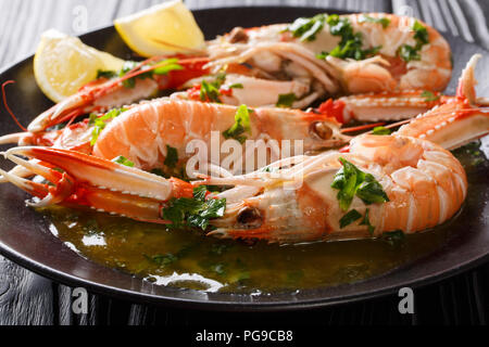 Gekochte Nephrops norvegicus, Kaisergranat, Dublin Bay Garnelen, Scampi oder Scampi close-up auf eine Platte, mit Soße und Zitrone. Horizontale Stockfoto