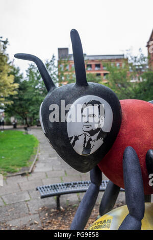 Manchester Biene mit dem Bild von Alan Turing in der Biene, s Auge mit einer Statue von Alan Turing hinter der Biene. Stockfoto