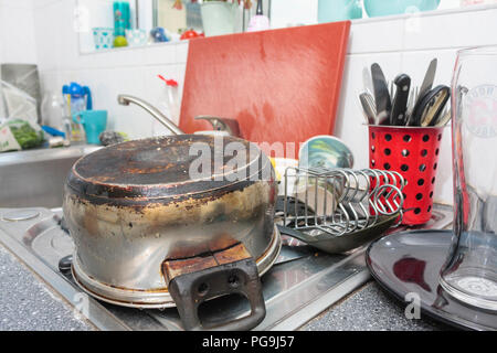 Ein Haufen reinigen Küchengeräte auf der Abtropffläche der Spüle Stockfoto