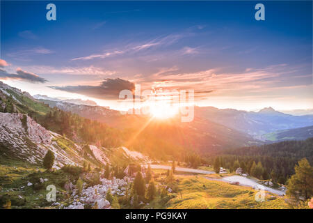 Sonnenlicht über die PUES Geisler Nationalpark mountain Gruppe mit einem hohen Ansehen der St. Kassian Dorf und den Peitlerkofel einsame Spitze oben Stockfoto